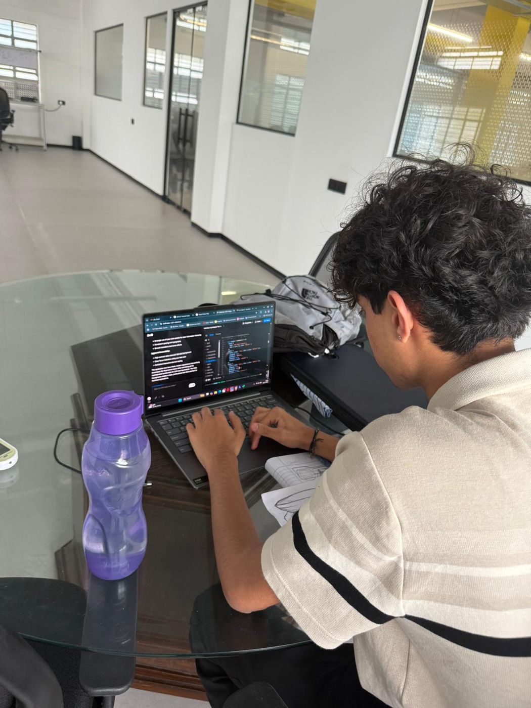 Kanishk typing on a laptop with code open in an editor