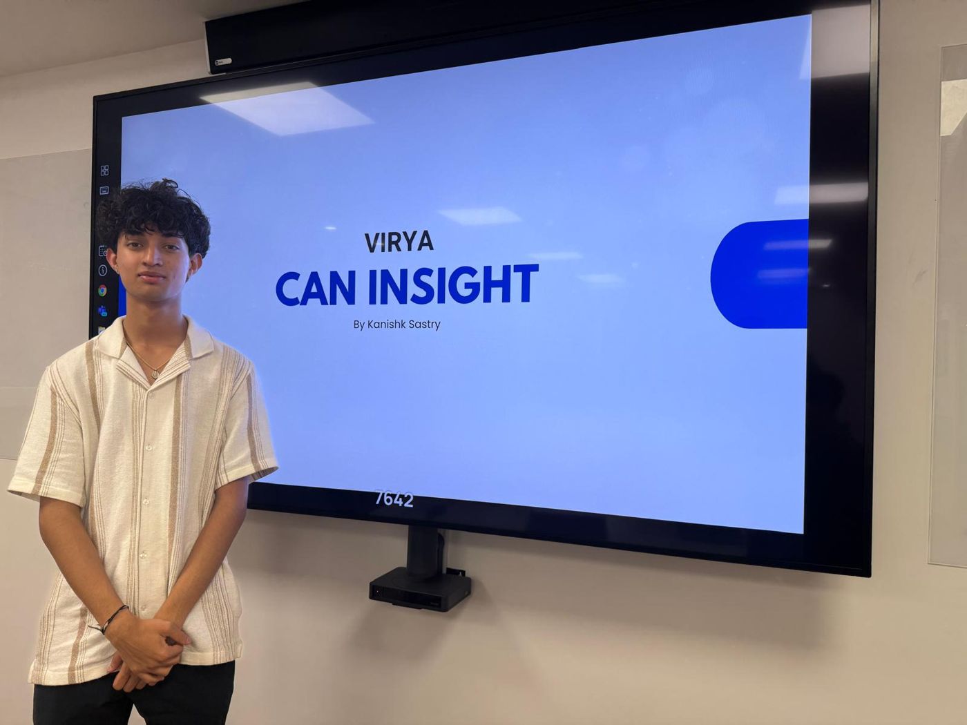 Kanishk standing beside a screen showing the title slide 'Virya CAN Insight, by Kanishk Sastry'